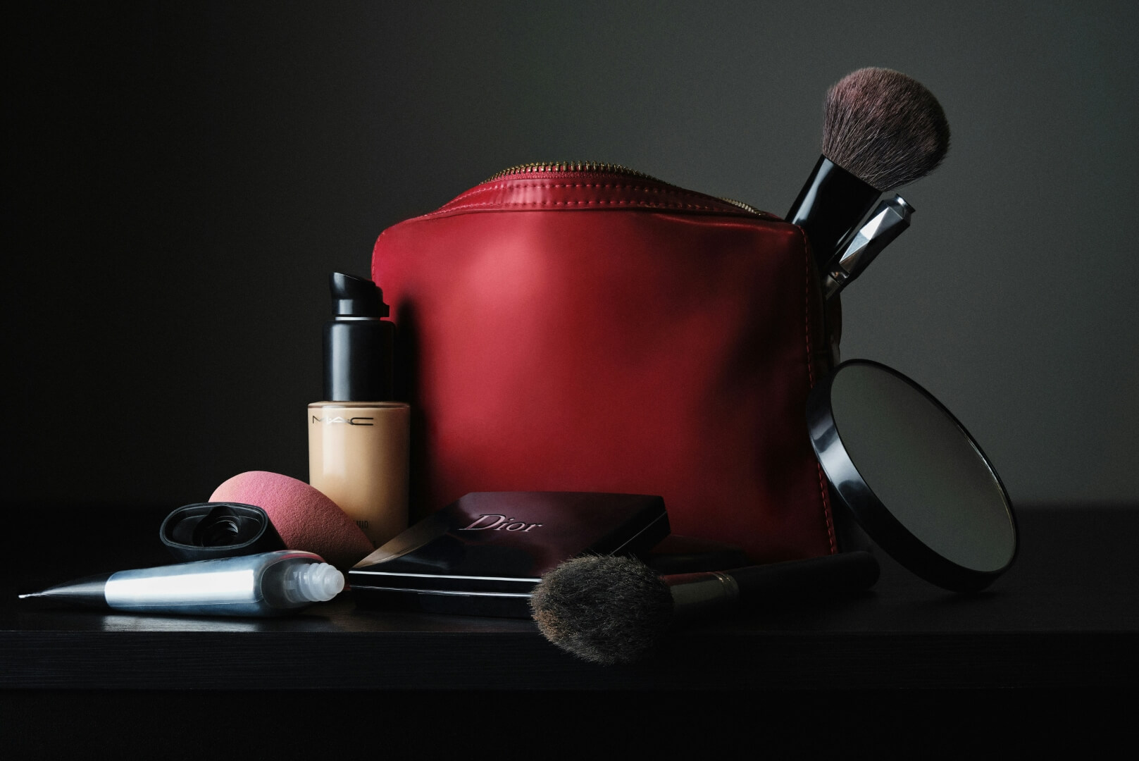 ¿Cómo elegir un neceser para tu maquillaje? Guía definitiva sobre cómo ordenar el maquillaje. En la imagen, un neceser rojo con diferentes utensilios de maquillaje.